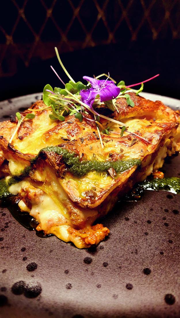Fatia de lasanha à bolonhesa com camadas de massa fresca, molho branco e queijo gratinado