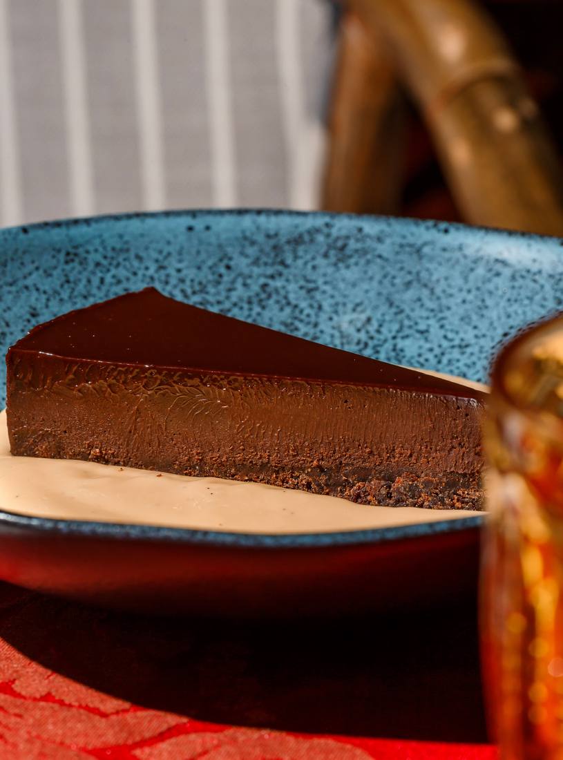 Fatia de crostata de chocolate com ganache 70% Callebaut sobre creme inglês